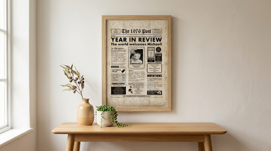 Milestones Studio Birthday Year You were Born newspaper in Timber Frame styled on warm wall with timber console and vase.